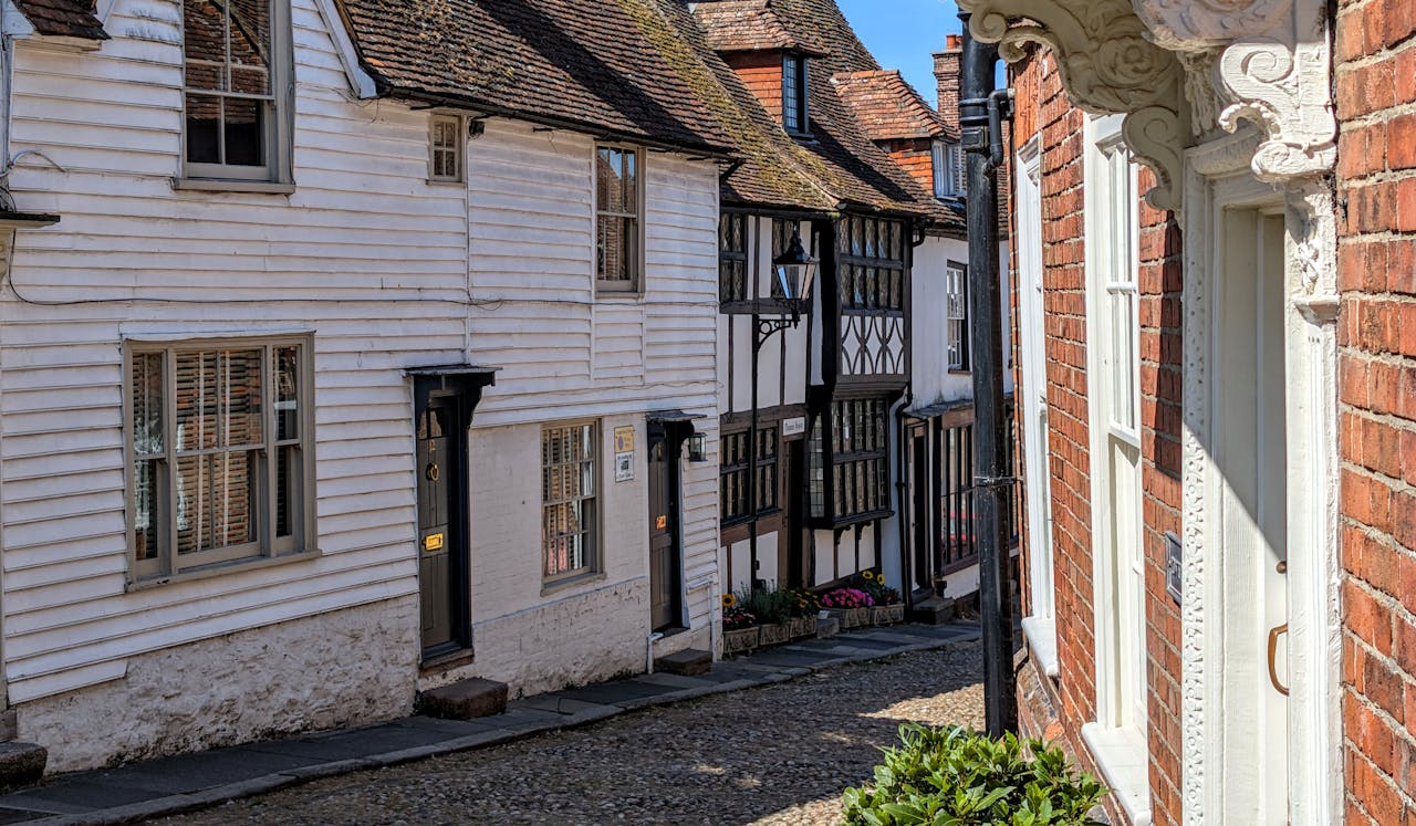 Medieval architecture along a cobbled street in Rye, England showcases historic charm.